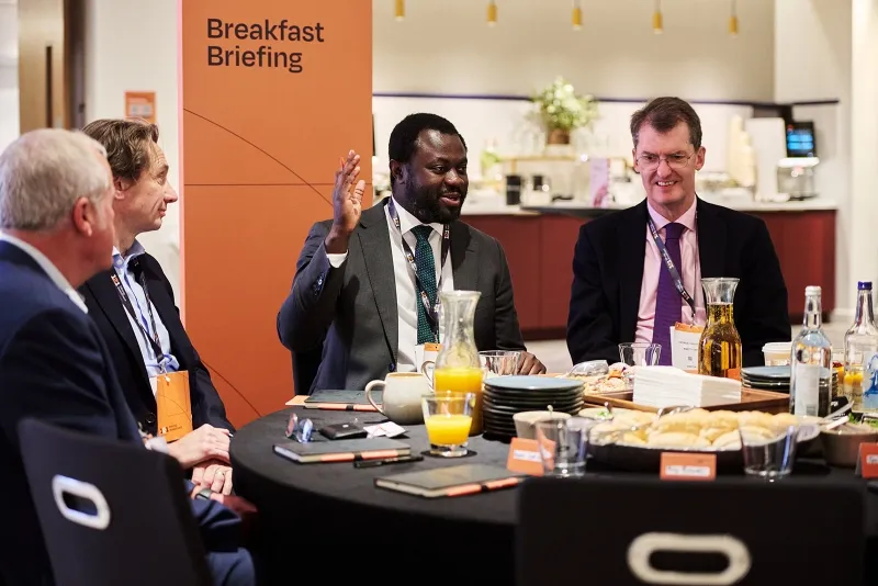 Mining industry professionals discussing market insights during a breakfast briefing